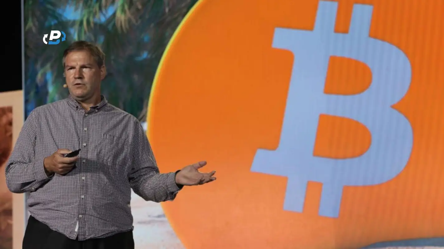Nick Szabo in front of the Bitcoin logo