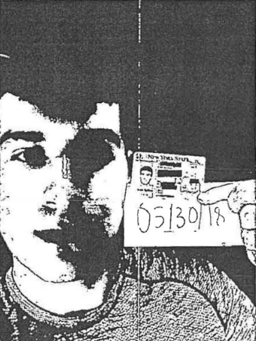 A low-quality image showing Nicholas Truglia holding an ID next to his face, which is standard procedure for online identity verification